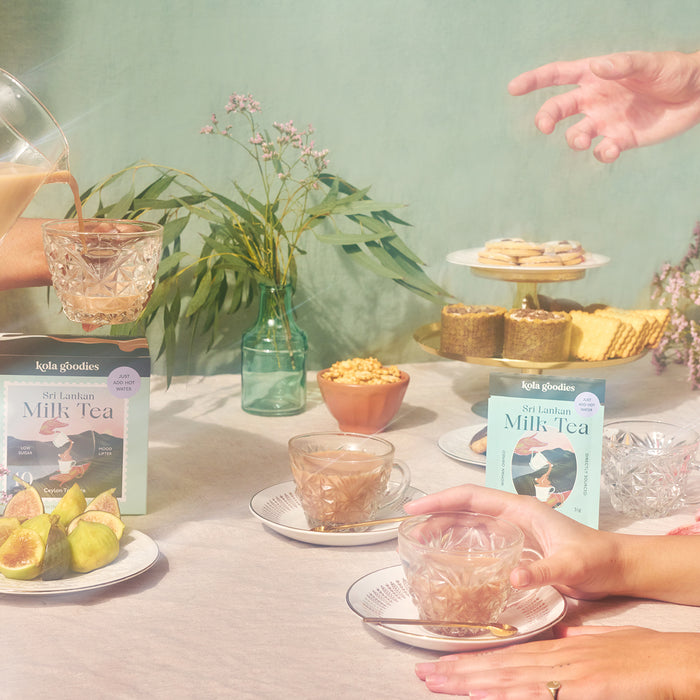 Kola Goodies' Sri Lankan milk tea displayed in a professional photo shoot, with the tea being poured and served to several people